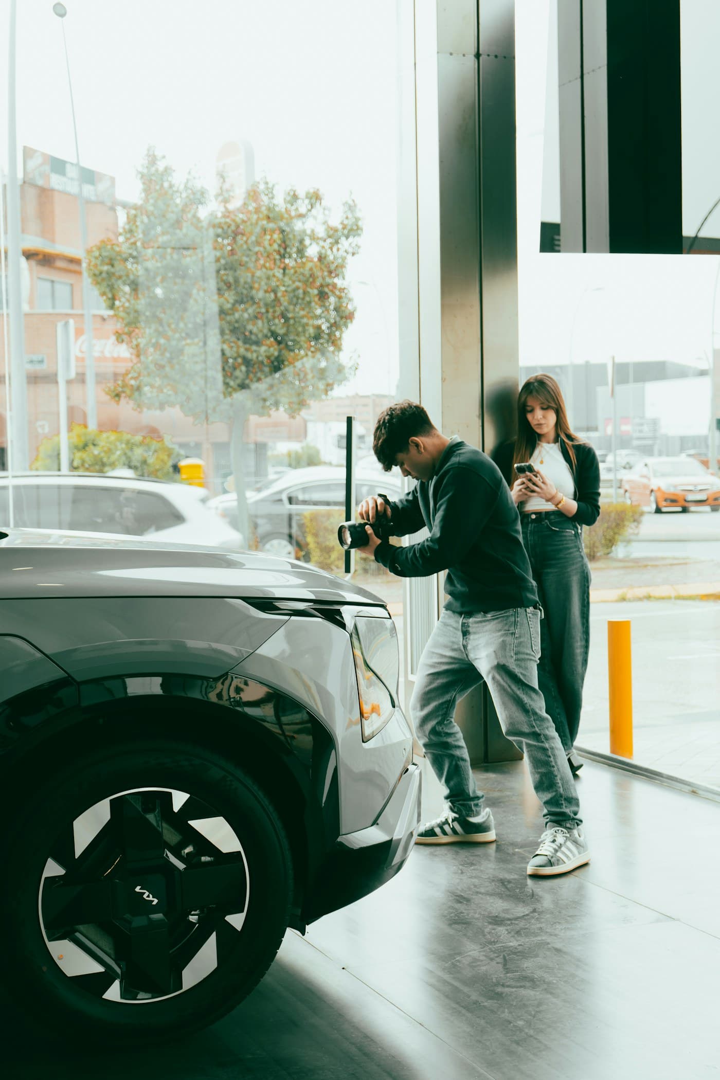 Two colleagues at work beside a car in a showroom
