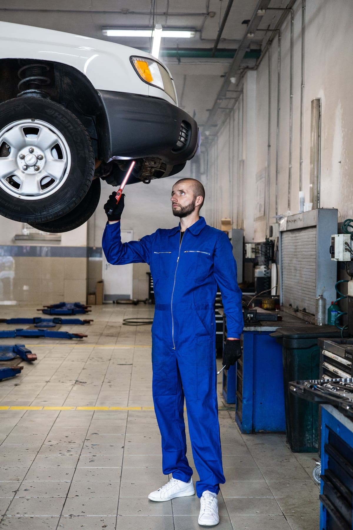 A mechanic working beneath a car on a lift